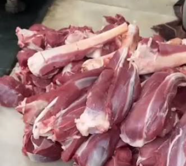 Cuts of fresh red meat resting on a wooden board.